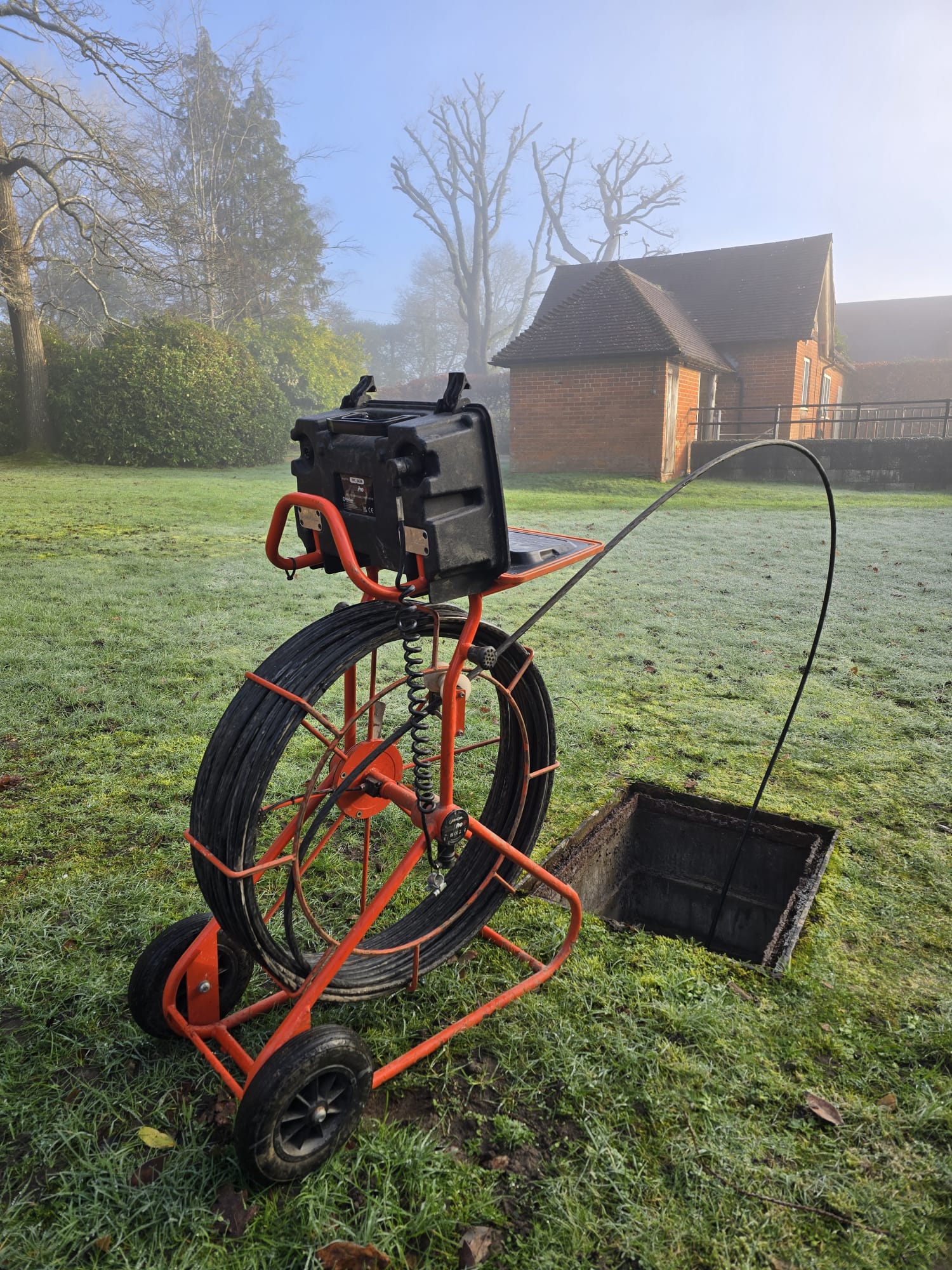 CCTV drain survey camera reel on frosted lawn