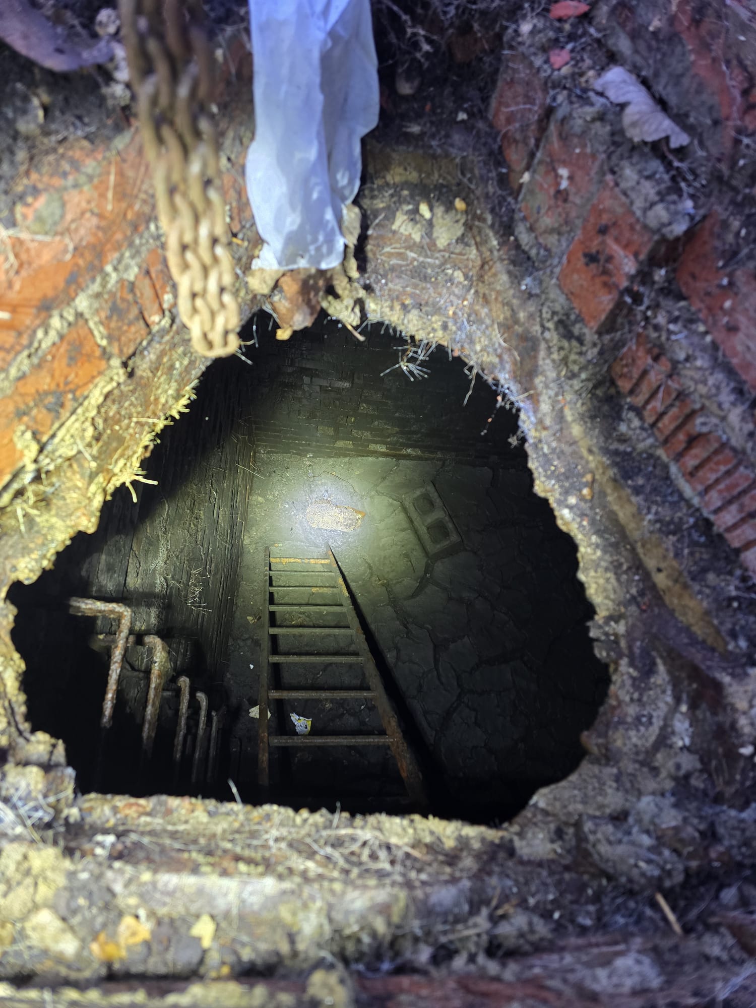 Deep brick-lined manhole with access ladder