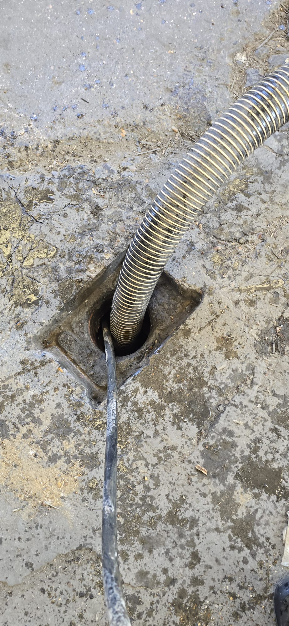 Tanker suction hose lifting waste from gully pot